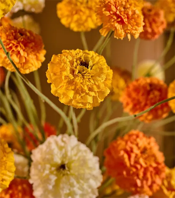 This stunning floral arrangement showcases silk flowers from the esteemed brand Silk-ka, crafted with meticulous attention to detail. Each flower, in vibrant shades of orange, yellow, and white, is a work of art in itself, evoking the freshness and delicacy. The craftsmanship is evident in the realistic petals and stems, giving this bouquet an elegant and refined look, perfect for enhancing any interior space.