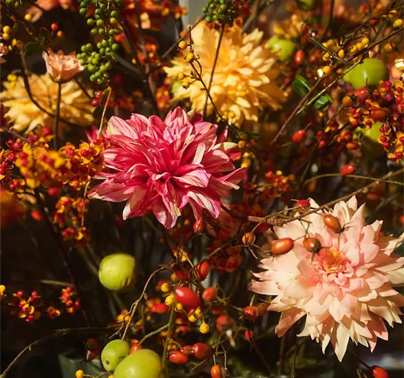 This image highlights the exquisite craftsmanship of Silk-ka's silk flowers. The vibrant pinks, soft peaches, and golden hues create a stunning floral arrangement that is almost indistinguishable from real flowers. The intricate detailing of each petal, coupled with the rich colors and natural textures, exemplifies the high-quality artistry for which Silk-ka is known. This elegant bouquet, with its mix of blossoms and delicate berries, brings a touch of luxury and timeless beauty to any setting.