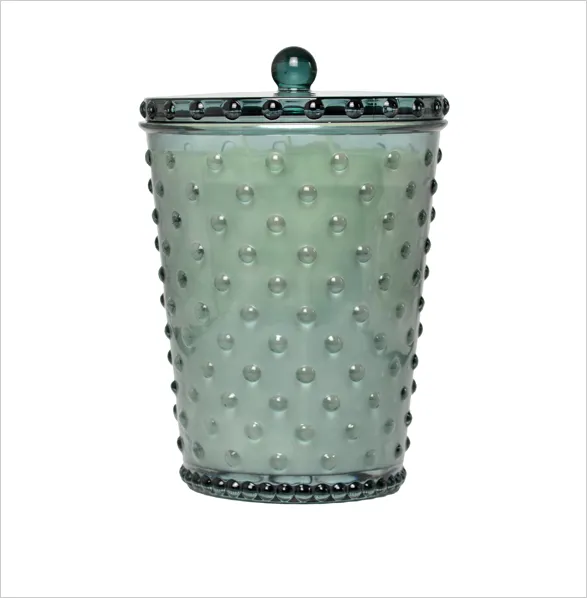 A beautifully crafted glass candle from the Simpatico brand, featuring an elegant hobnail texture that adds a touch of vintage charm. This artisanal piece, made in the USA, showcases Simpatico's commitment to quality and design. The candle is poured with a clean-burning, long-lasting natural soy wax blend, offering a delightful and soothing fragrance that complements the aesthetic appeal of the glass container.