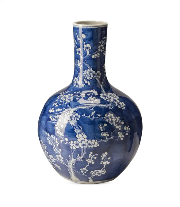 Exquisite POLSPOTTEN vase featuring a striking blue and white cherry blossom design. The globular body transitions elegantly into a slender neck, showcasing delicate hand-painted branches and blossoms against a deep blue background. This piece exemplifies the brand's commitment to iconic, nature-inspired designs that enrich interior spaces with timeless beauty.