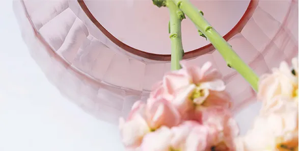 Exquisite Guaxs glass vase in delicate pink, showcasing the brand's mastery of handblown glasswork. The vase's soft, rounded form captures light beautifully, complementing the gentle hues of blush flowers it holds. A testament to Guaxs' commitment to timeless design and artisanal craftsmanship.