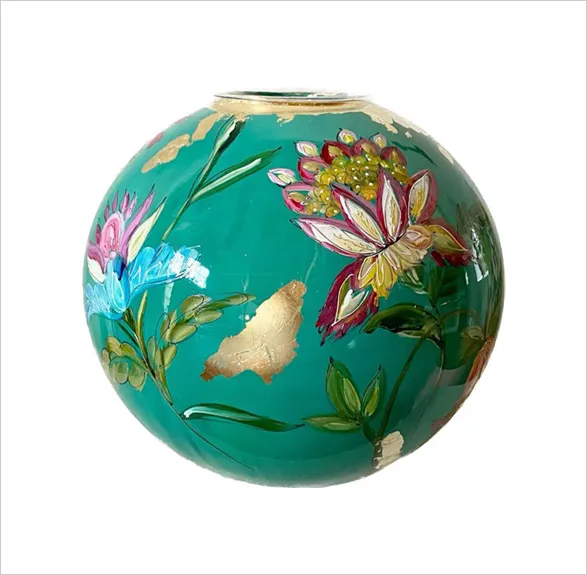Exquisite hand-painted glass vase 'Jade' by renowned Dutch artist Doortje IJpellar. This spherical masterpiece features a vibrant jade green background adorned with delicate lotus flowers in pink and gold, alongside lush foliage. Golden accents highlight the rim and intricate details, creating a harmonious blend of colors. A limited edition piece, signed by the artist and crafted in her Netherlands studio, accompanied by a certificate of authenticity.