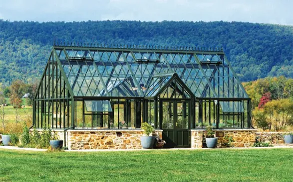 Majestic Hartley Botanic greenhouse stands proudly against a backdrop of rolling forested hills. This RHS-endorsed masterpiece showcases the brand's 200-year heritage of unparalleled quality and perfect design. With its elegant Victorian-inspired architecture, durable glass panels, and sturdy stone base, this greenhouse embodies Hartley Botanic's commitment to enduring strength and everlasting performance. A testament to horticultural excellence, backed by a 30-year guarantee, inviting gardeners to cultivate their passion in a structure built to last generations.