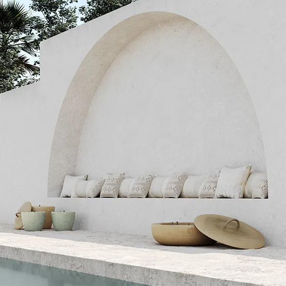 Serene Mediterranean-inspired terrace featuring Mon Dada's elegant outdoor concrete candles. Soft-hued vessels in earthy tones complement the minimalist white archway and cushioned seating. The Belgian brand's artisanal candles add a touch of warmth and sophistication to this tranquil outdoor space, showcasing their commitment to blending functionality with timeless design.