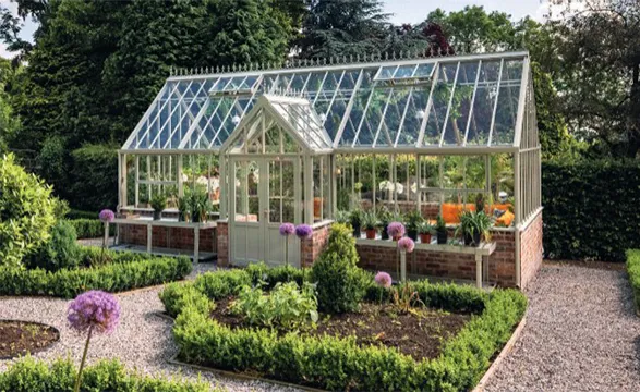 The greenhouse in the image exemplifies Hartley Botanic's commitment to creating structures that are both functional and aesthetically pleasing. Its classic Victorian design reflects the brand's respect for horticultural heritage, while the modern engineering ensures optimal growing conditions for plants. The seamless integration of the greenhouse into its natural surroundings showcases Hartley Botanic's ability to create spaces that enhance rather than compete with their environment, offering gardeners a beautiful and practical haven for their passion.